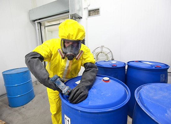 person in hazmat suit working with blue barrel of hazardous chemical. Hazardous waste, Solid Waste, TCLP test, Hazardous Waste characterization, Waste Characterization, RCRA waste characterization